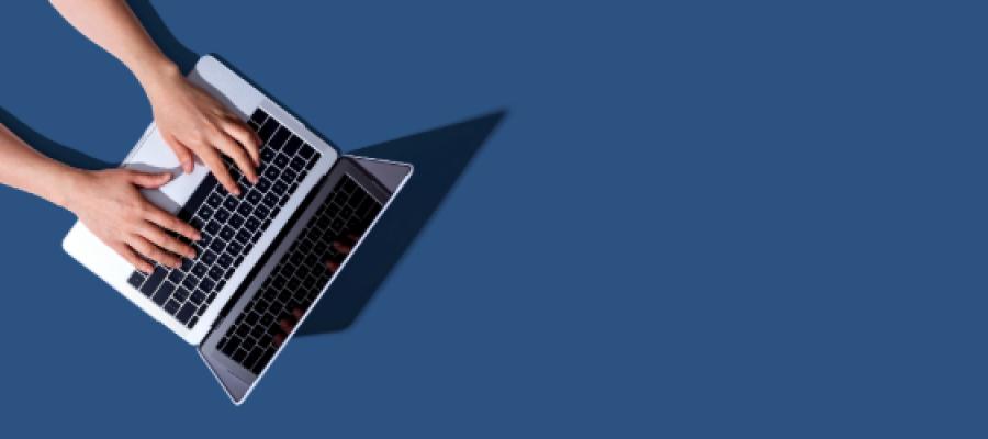 Hands typing at a laptop