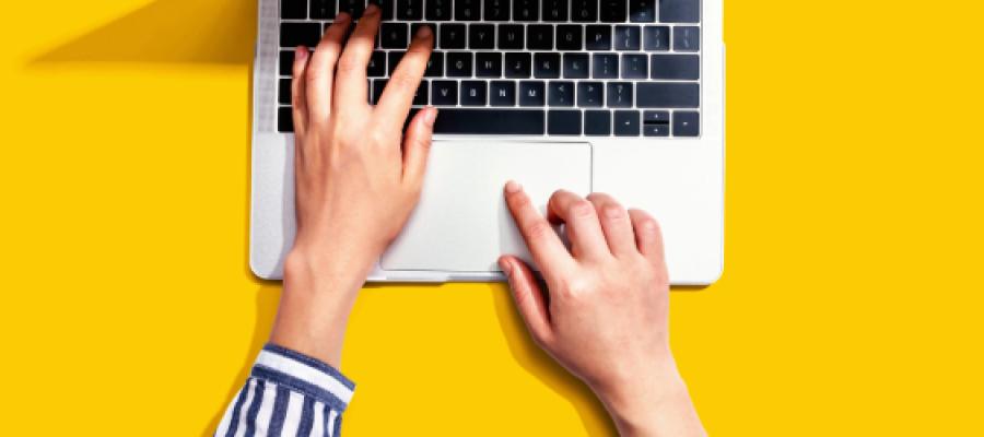 Hands typing at a laptop